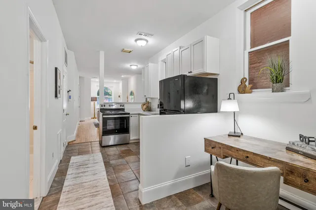 a kitchen with stainless steel appliances a sink a stove a microwave a refrigerator and cabinets