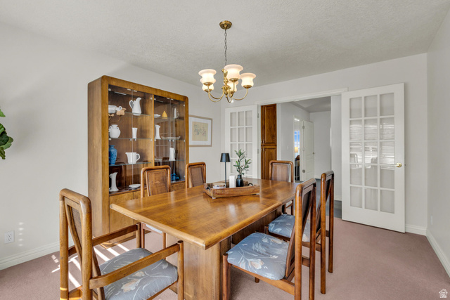 1060 West 2620th Street South Mapleton, UT 84664 - Photo 13 of 87 Dining area featuring light carpet, a chandelier, and a textured ceiling