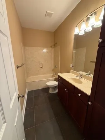 a bathroom with a double vanity sink toilet mirror and bathtub