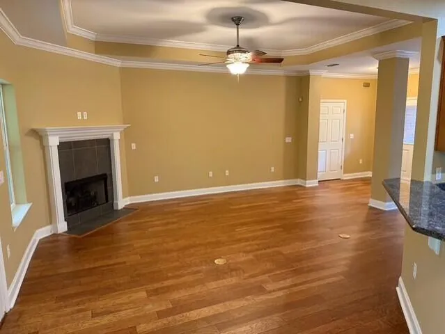 a view of an empty room with a fireplace and chandelier fan