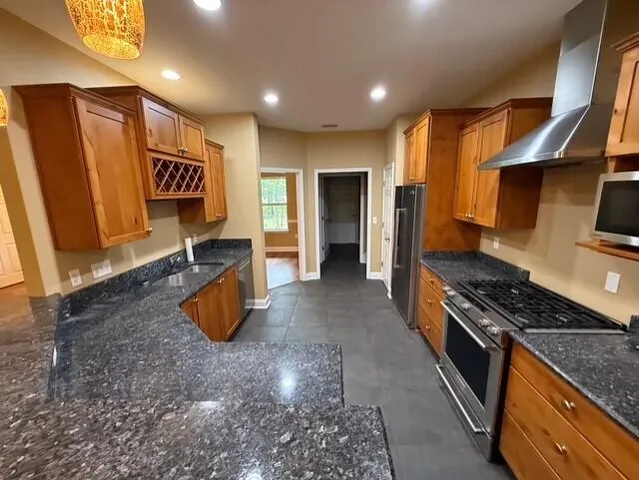 a kitchen with stainless steel appliances granite countertop a stove a sink and a refrigerator