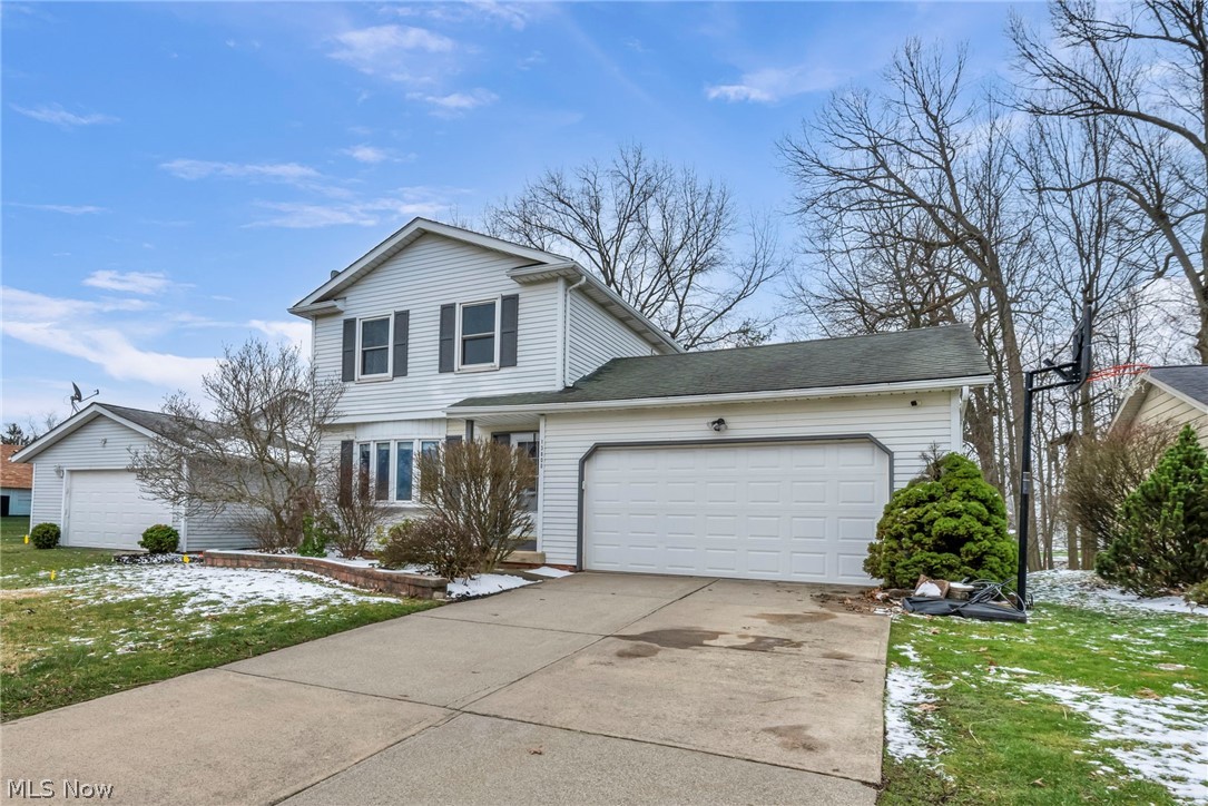 13800 Milo Road Garfield Heights, OH 44125 - Photo 31 of 39 Traditional-style home with a garage, concrete driveway, a lawn, and a shingled roof