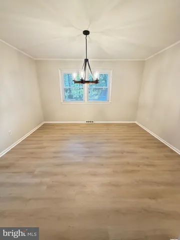 a view of a room with wooden floor ceiling fan and window