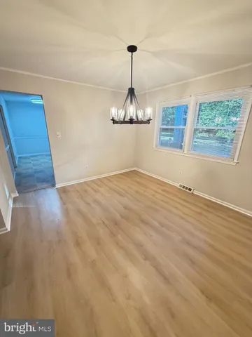 a view of a livingroom with wooden floor and a chandelier