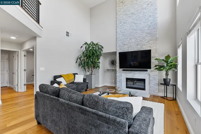 a living room with furniture a flat screen tv and a fireplace