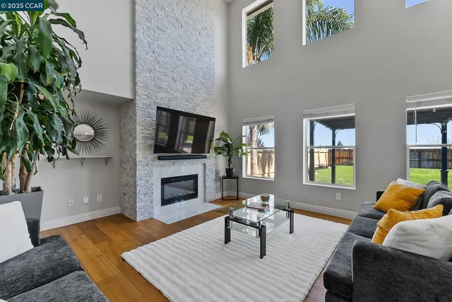 a living room with furniture a flat screen tv and a fireplace