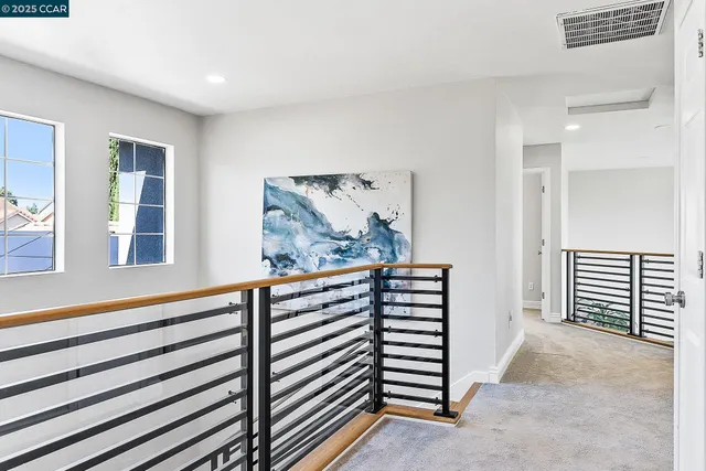 a view of a hallway with windows and stairs