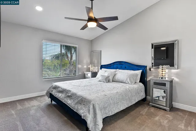 a bedroom with a bed and a flat tv screen on dresser