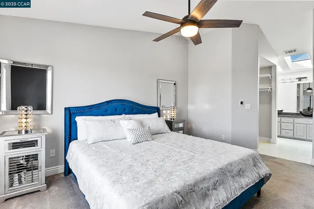 a bedroom with a large bed and a chandelier
