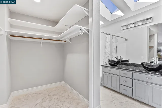 a bathroom with a granite countertop sink a mirror and a shower