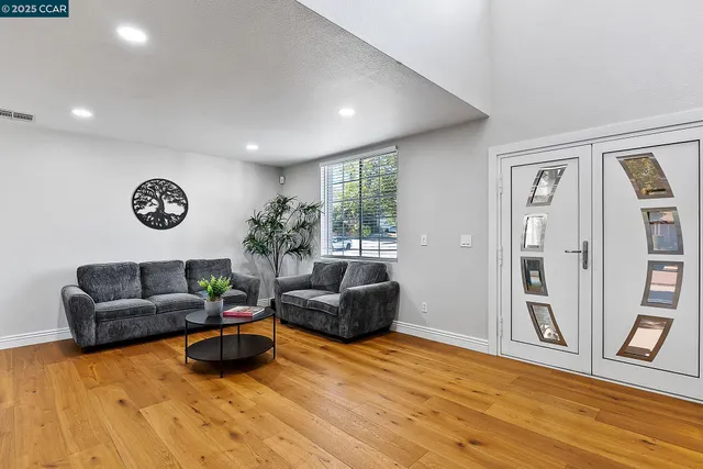 a living room with furniture and a wooden floor