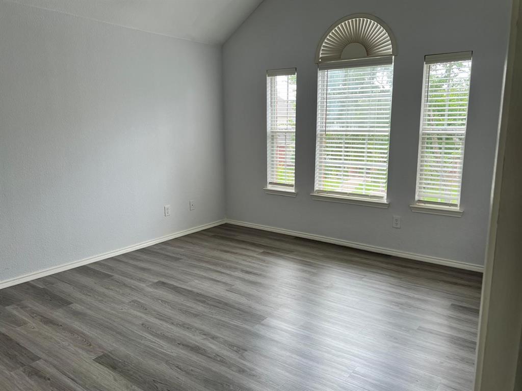 4312 Ridge Point Lane Plano, TX 75024 - Photo 12 of 16 an empty room with wooden floor and windows