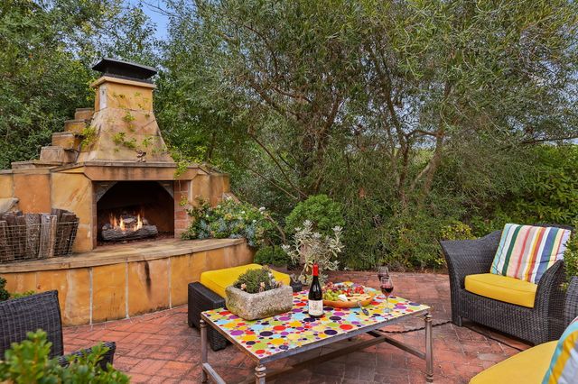 an outdoor living area with furniture and a fireplace