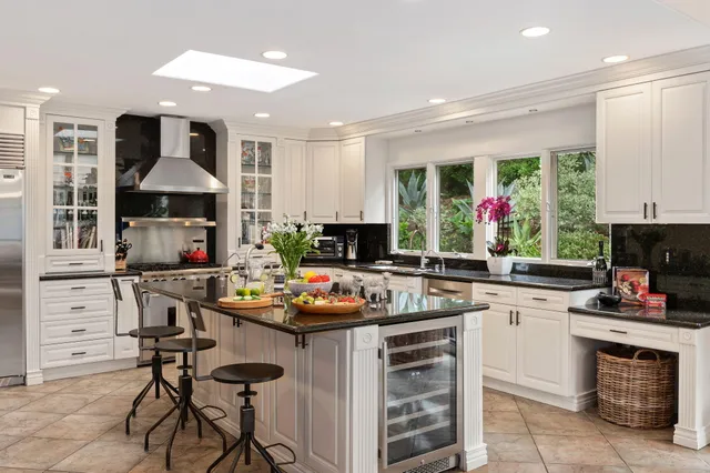 a kitchen with a stove a refrigerator and a dining table with wooden floor