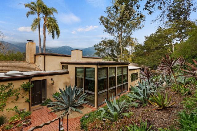 a view of a house with a window and wooden fence