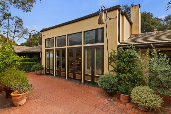 a view of a house with a potted plant and a bench