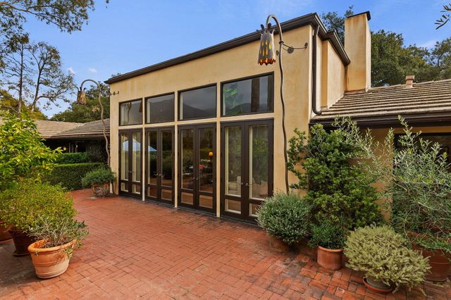 a view of a house with a potted plant and a bench