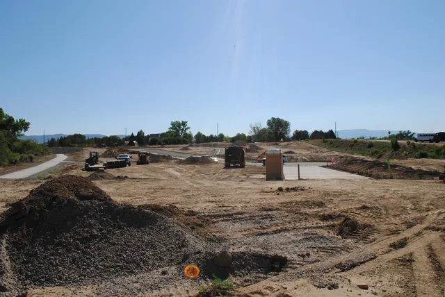 a view of a dry yard with wooden fence