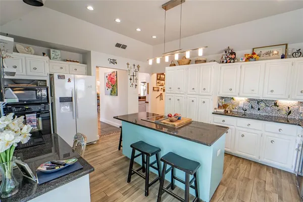 a large kitchen with lots of counter space and wooden floor