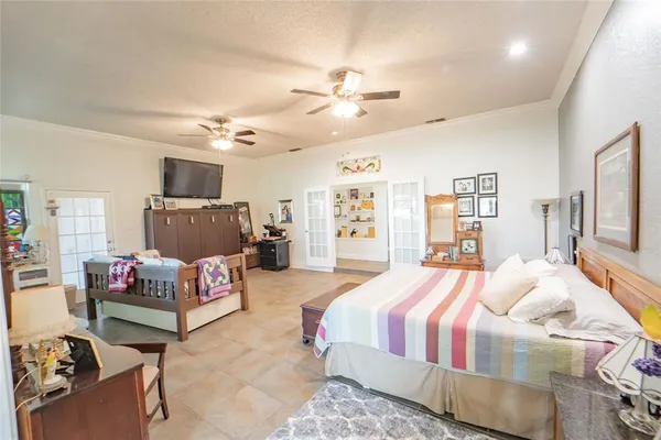 a spacious bedroom with a bed and a chandelier