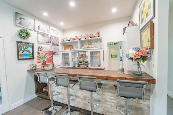 a living room with furniture a flat screen tv and kitchen view