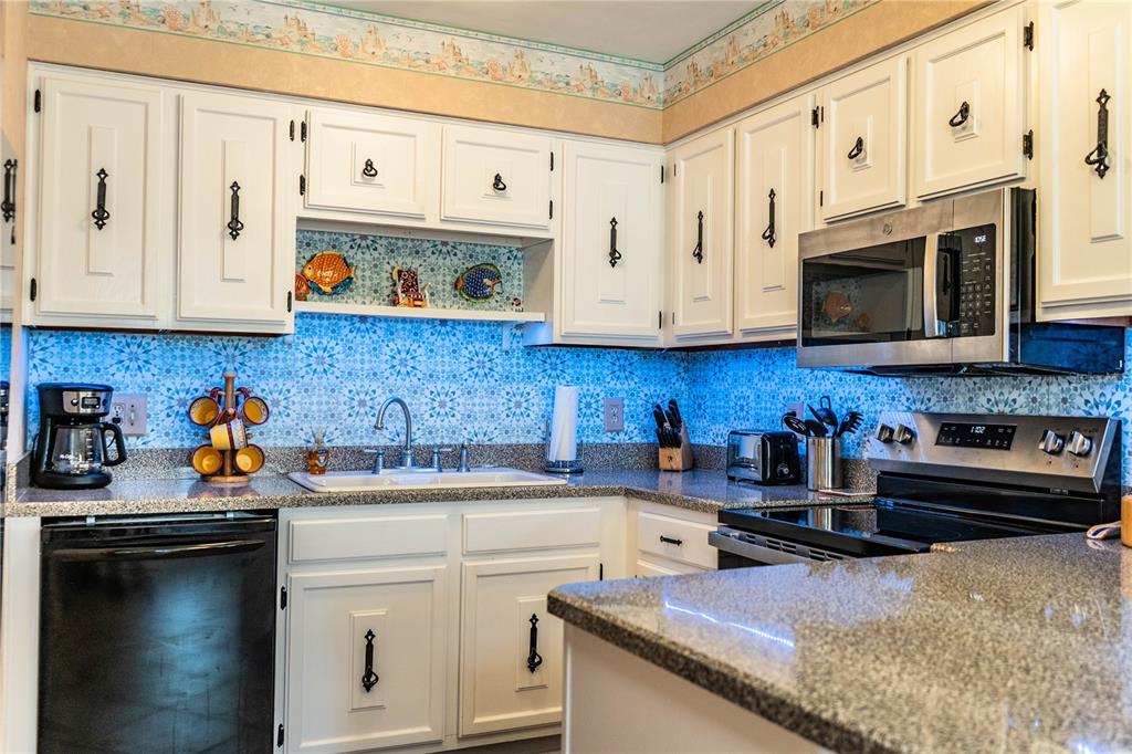 1305 Arbuckle Creek Road Sebring, FL 33870 - Photo 24 of 71 a kitchen with stainless steel appliances granite countertop a sink dishwasher stove and cabinets with wooden floor