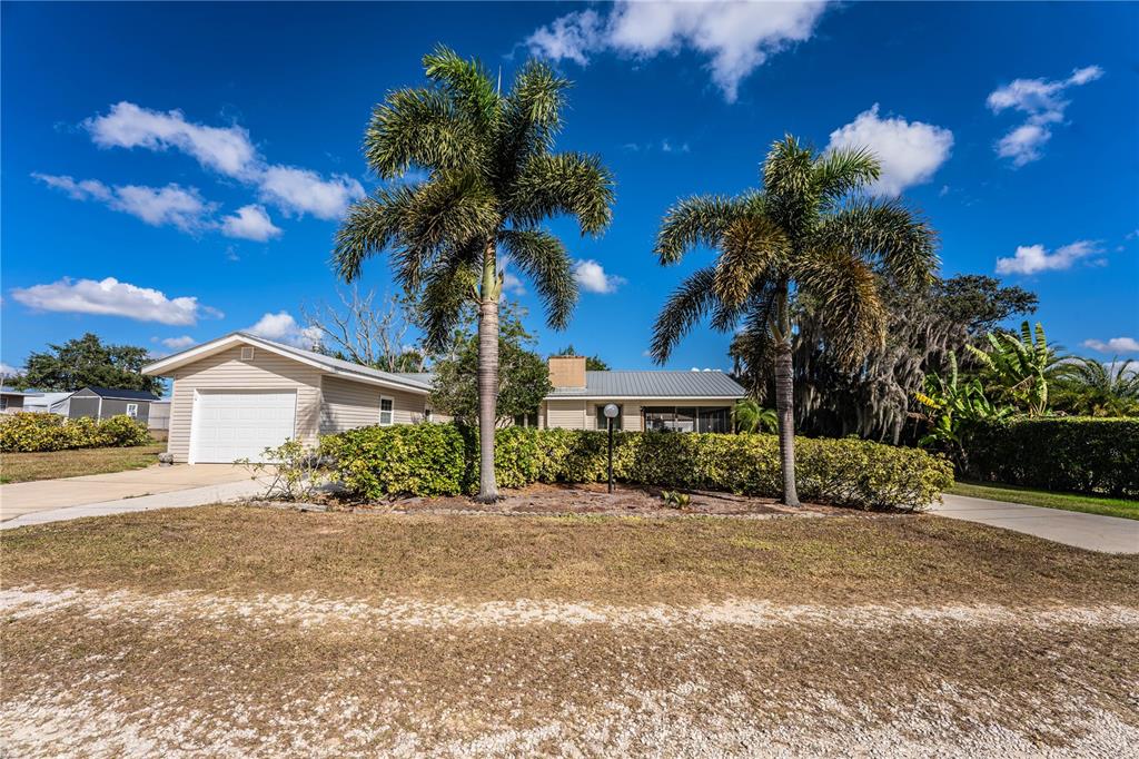 1305 Arbuckle Creek Road Sebring, FL 33870 - Photo 70 of 71 a front view of a house with a yard and garage
