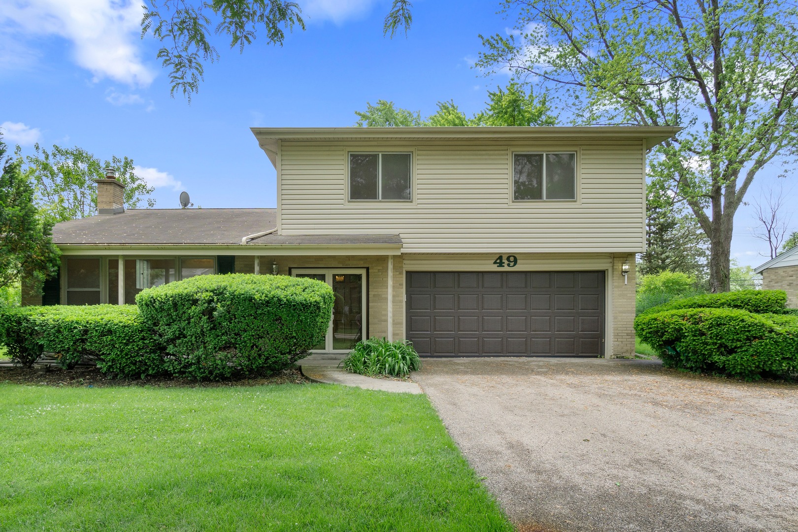 49 Mulberry Road Deerfield, IL 60015 - Photo 1 of 17 a front view of a house with a garden and plants
