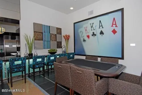a living room with furniture pool table and wall paintings