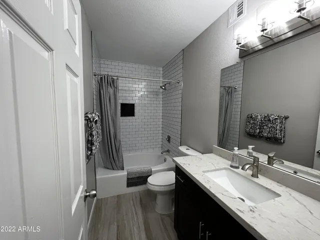 a bathroom with a double vanity sink toilet and shower