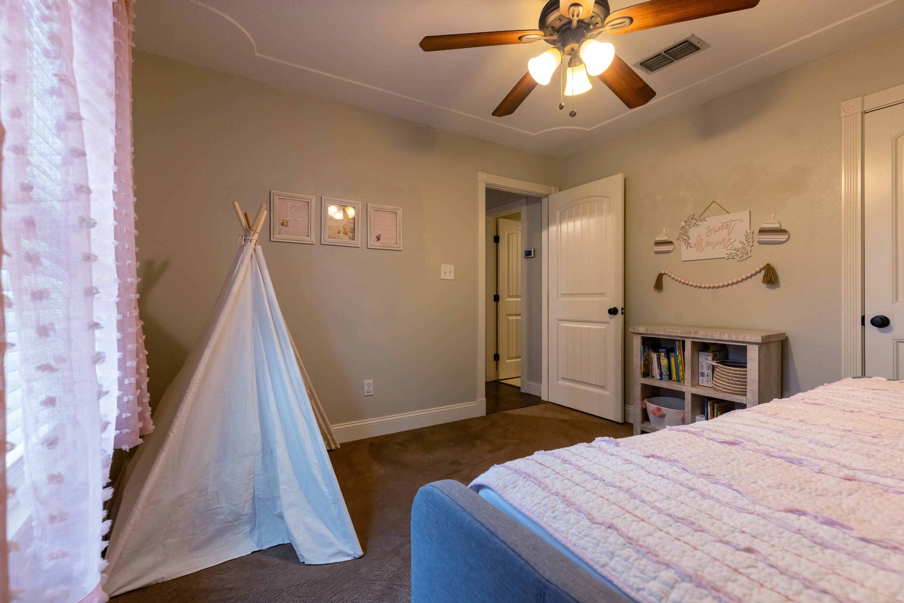 7807 Homestead Avenue Lubbock, TX 79424 - Photo 21 of 31 a bedroom with a bed and a chandelier