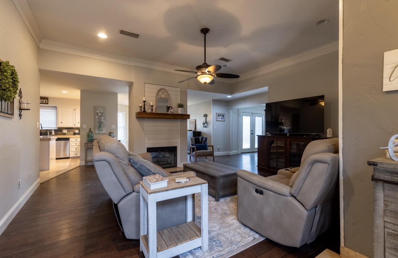 7807 Homestead Avenue Lubbock, TX 79424 - Photo 7 of 31 a living room with furniture a fireplace and a flat screen tv