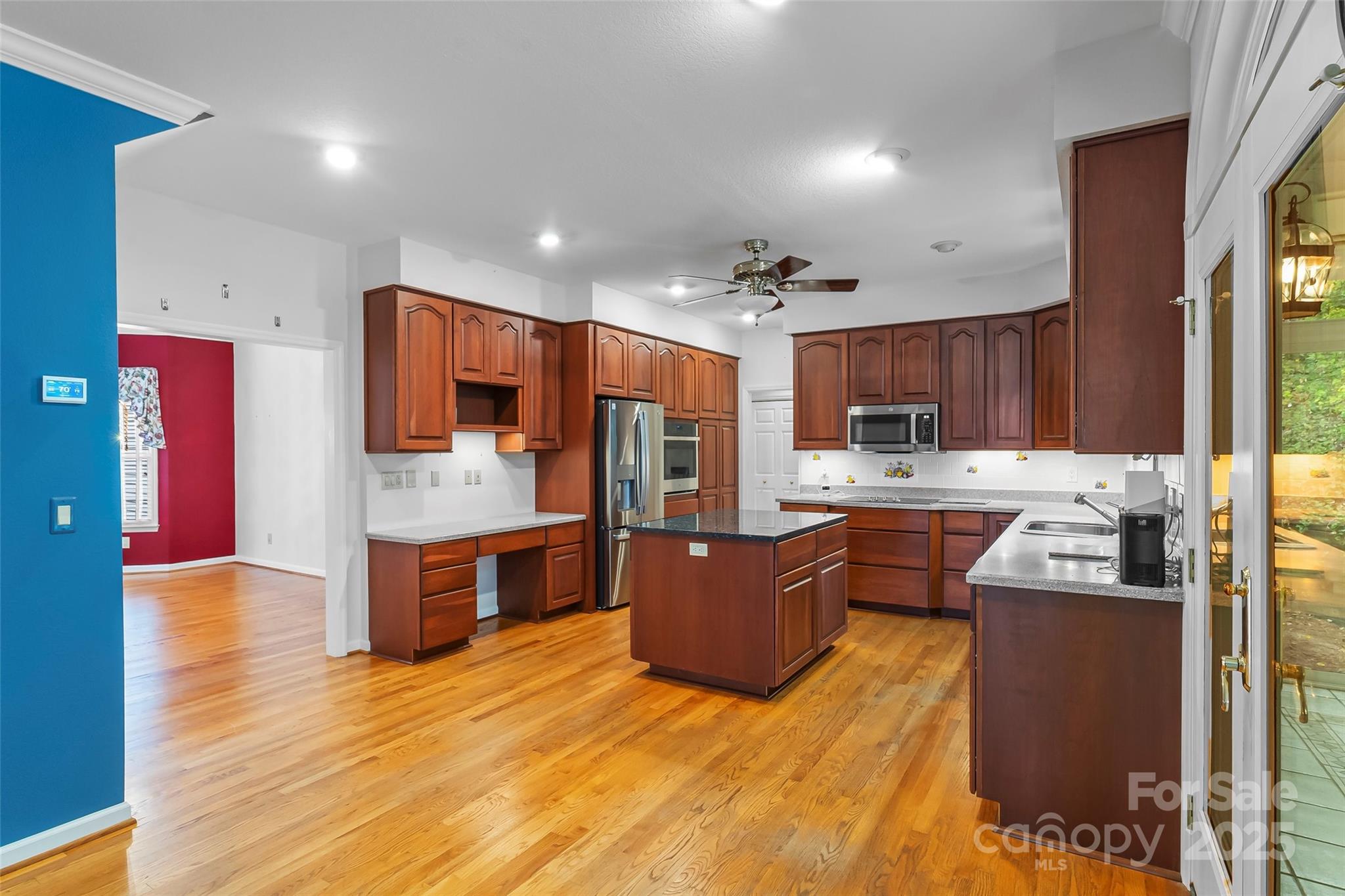 506 Kings Ridge Asheville, NC 28804 - Photo 11 of 44 a large kitchen with stainless steel appliances kitchen island granite countertop a refrigerator a stove top oven and a sink with wooden floor