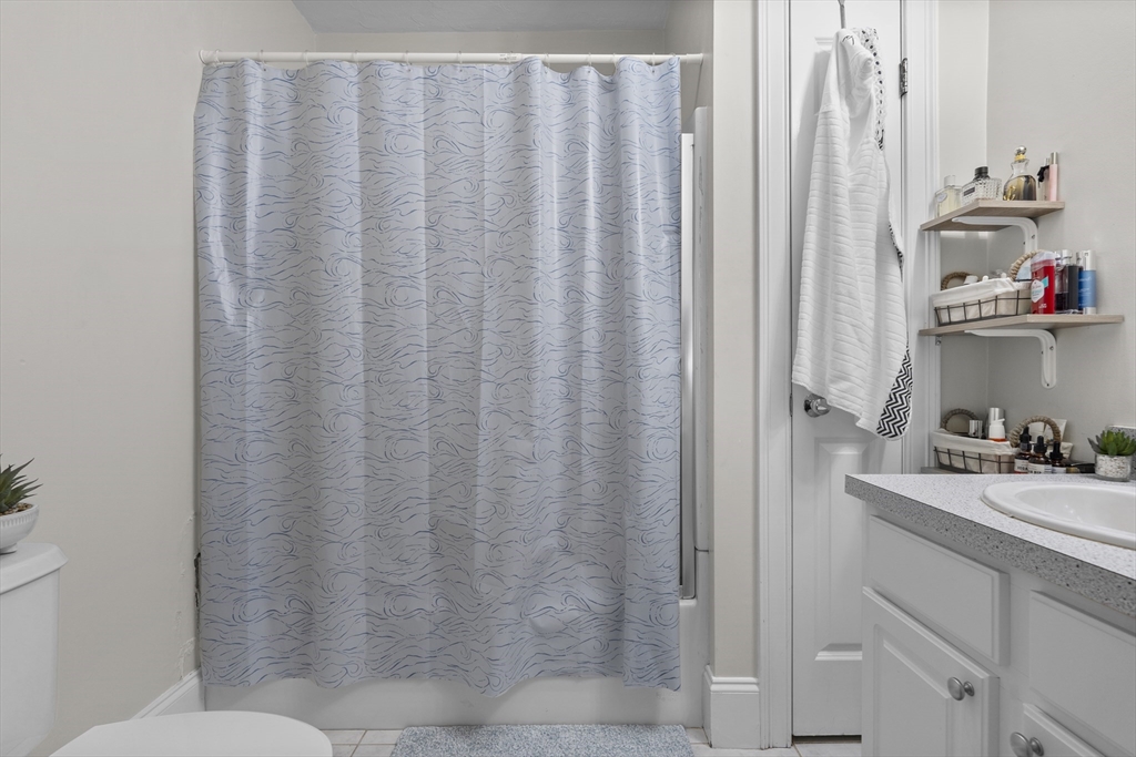 320 West Broadway, Unit 6 Boston, MA 02127 - Photo 11 of 14 a bathroom with a shower curtain and sink