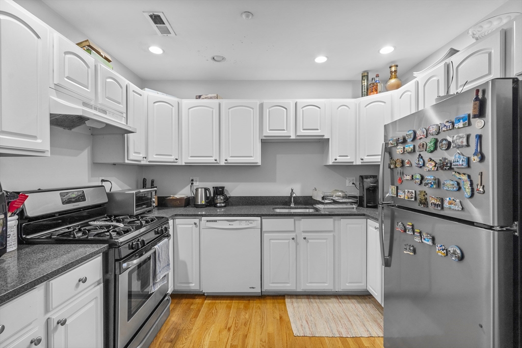 320 West Broadway, Unit 6 Boston, MA 02127 - Photo 2 of 14 a kitchen with stainless steel appliances granite countertop a stove a sink dishwasher and a refrigerator