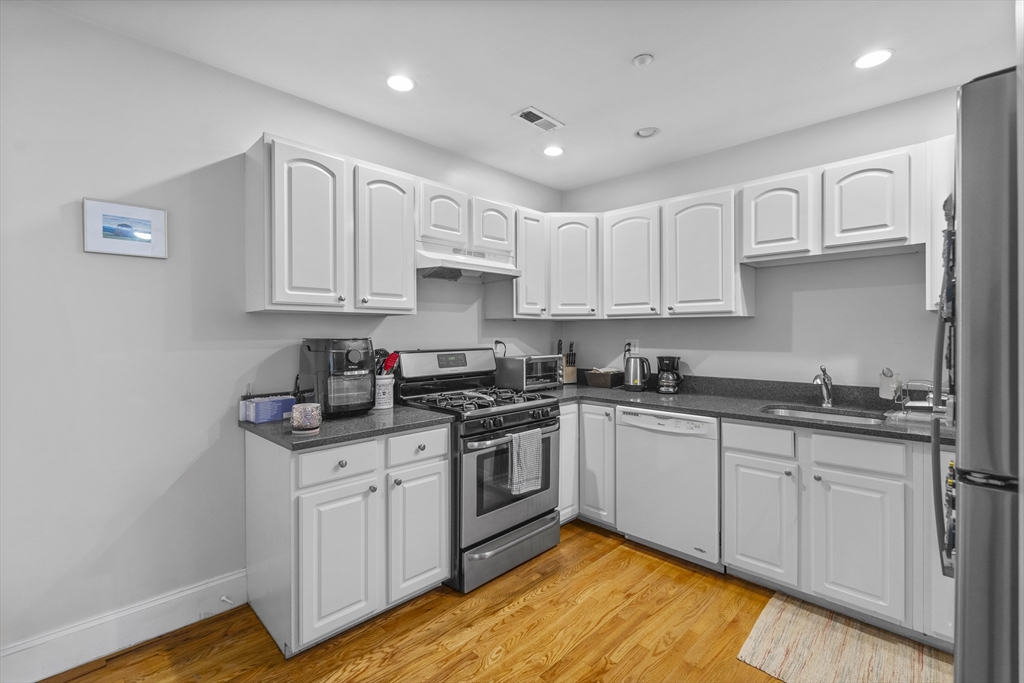 320 West Broadway, Unit 6 Boston, MA 02127 - Photo 3 of 14 a kitchen with stainless steel appliances granite countertop a sink and cabinets