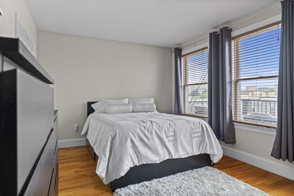 320 West Broadway, Unit 6 Boston, MA 02127 - Photo 6 of 14 a bedroom with a bed and wooden floor