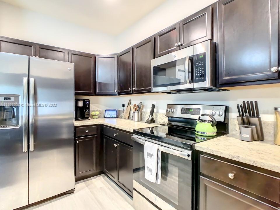 9326 West 33rd Lane Hialeah, FL 33018 - Photo 10 of 52 a kitchen with stainless steel appliances granite countertop a stove a sink and a refrigerator