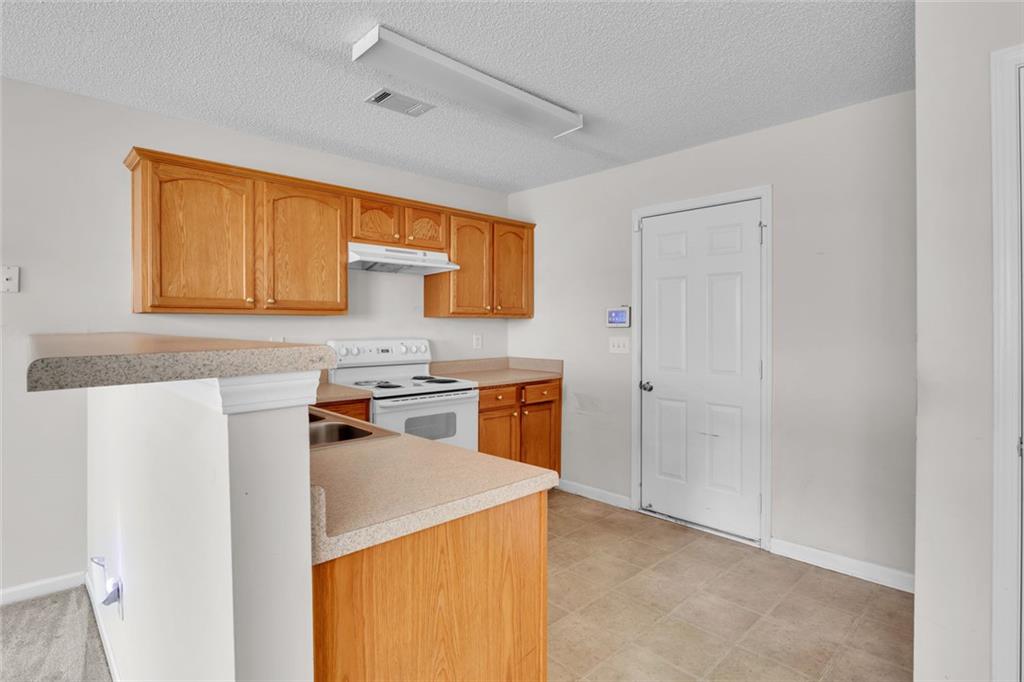 7243 April Court Morrow, GA 30260 - Photo 9 of 29 a kitchen with a stove a sink and a refrigerator
