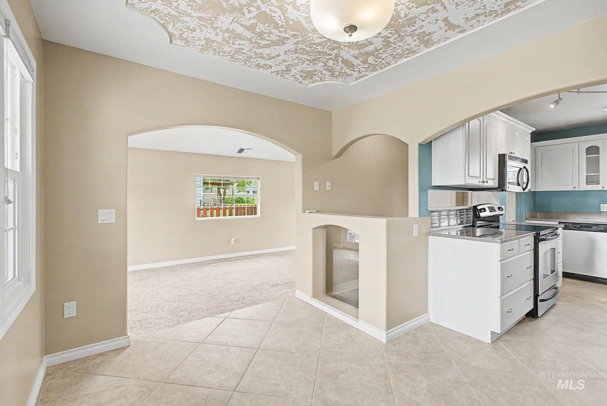 3314 6th Street Lewiston, ID 83501 - Photo 10 of 50 Kitchen area featuring white cabinetry, stainless steel appliances, and a tile backsplash
