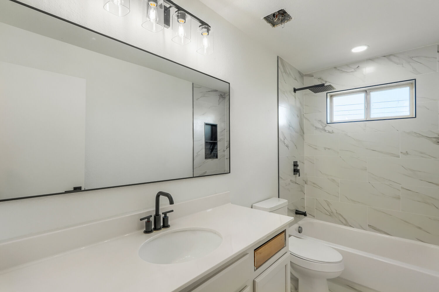 320 Triumph Road Buda, TX 78610 - Photo 15 of 22 Gleaming marble-patterned tile surrounds the modern tub and shower combination.