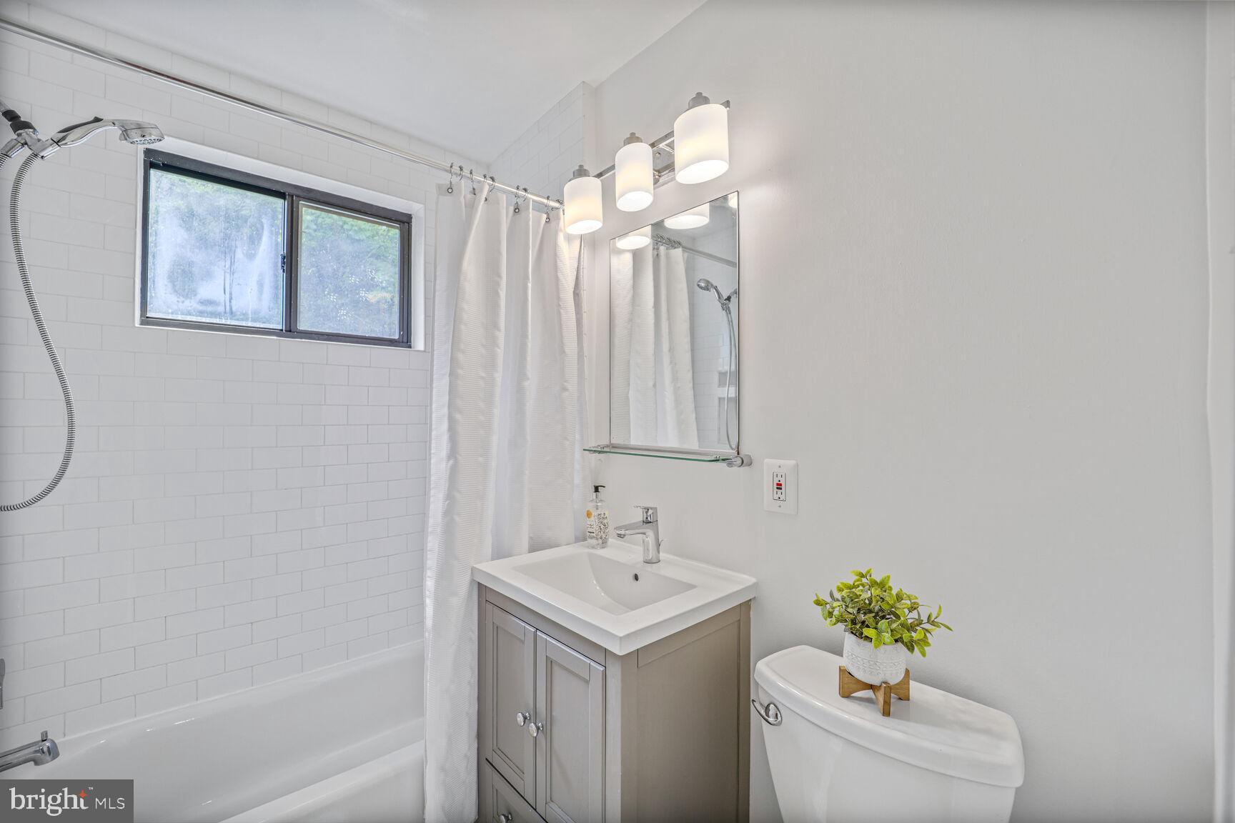 4114 Davis Place Northwest, Unit 311 Washington, DC 20007 - Photo 11 of 37 a bathroom with a sink a toilet and a mirror