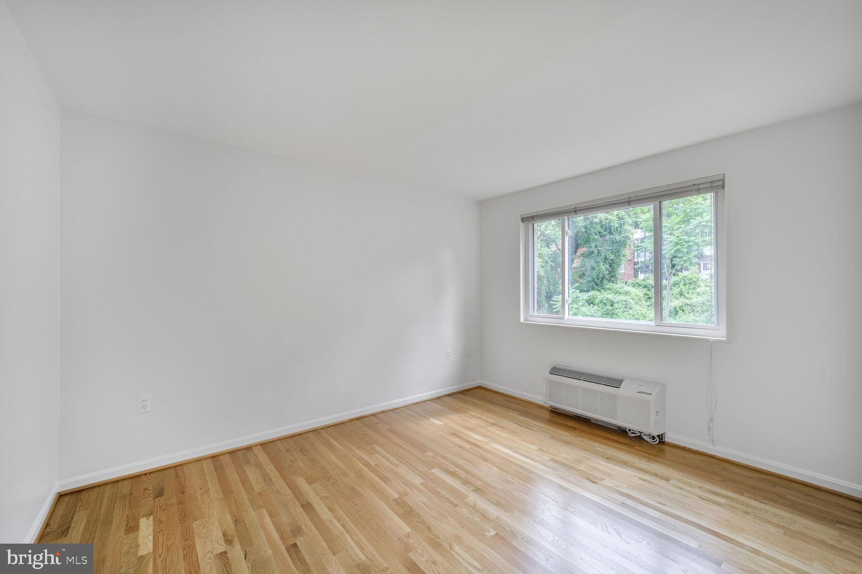 4114 Davis Place Northwest, Unit 311 Washington, DC 20007 - Photo 12 of 37 an empty room with wooden floor and windows