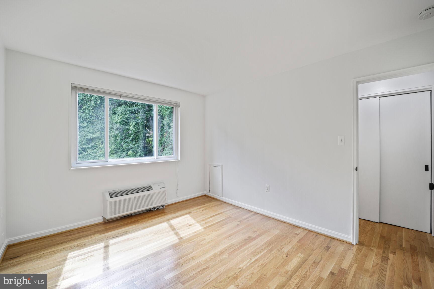 4114 Davis Place Northwest, Unit 311 Washington, DC 20007 - Photo 15 of 37 an empty room with wooden floor and windows
