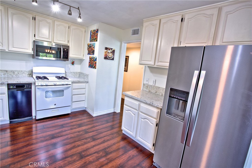 1083 Lakeview Terrace Azusa, CA 91702 - Photo 25 of 36 a kitchen with stainless steel appliances a refrigerator sink and wooden floor