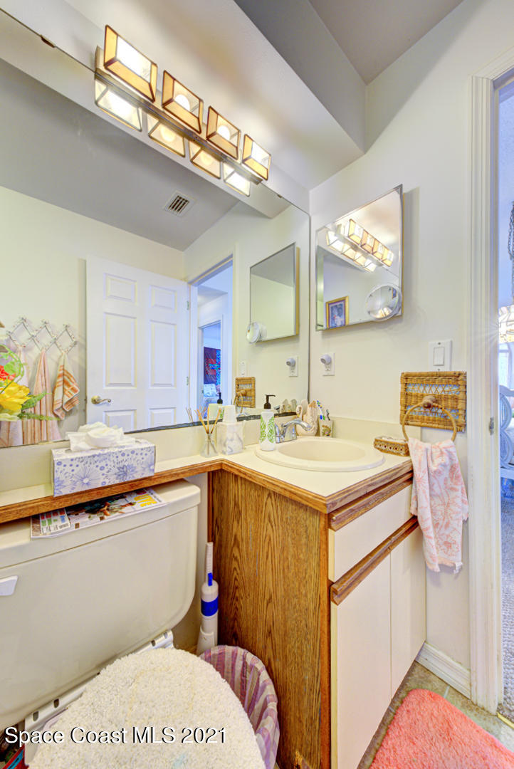 2225 Corey Road Malabar, FL 32950 - Photo 16 of 62 a bathroom with a sink a vanity and mirror