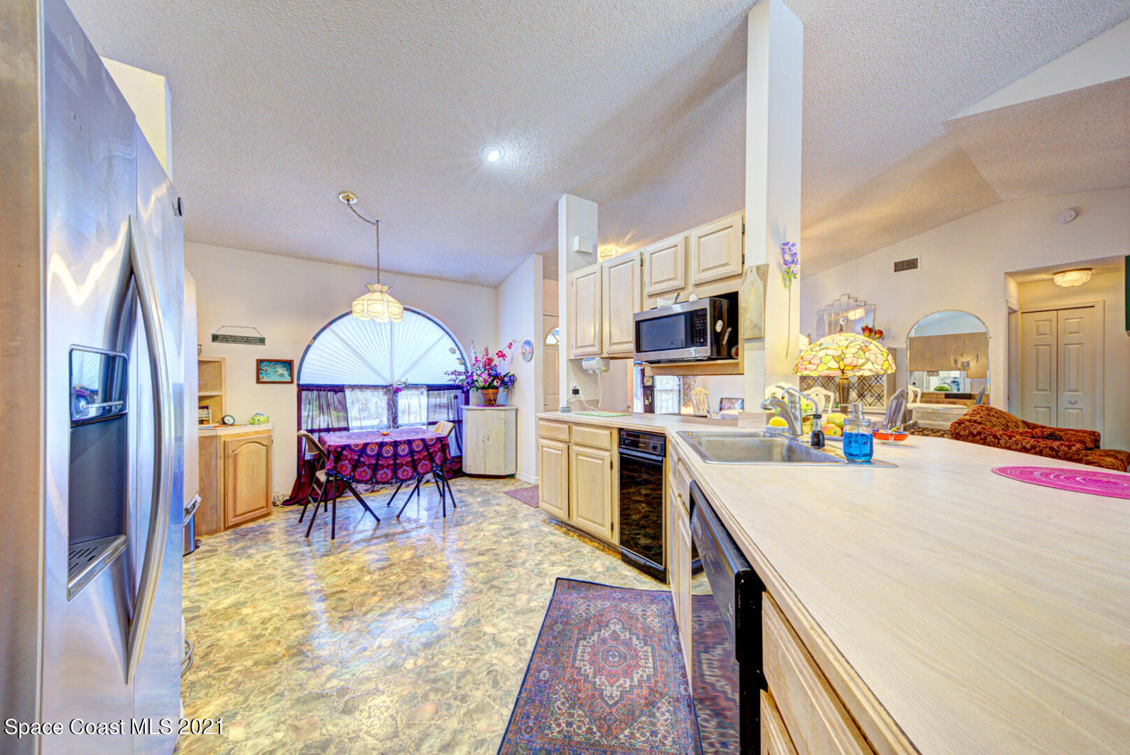 2225 Corey Road Malabar, FL 32950 - Photo 33 of 62 a kitchen with a table chairs microwave and refrigerator