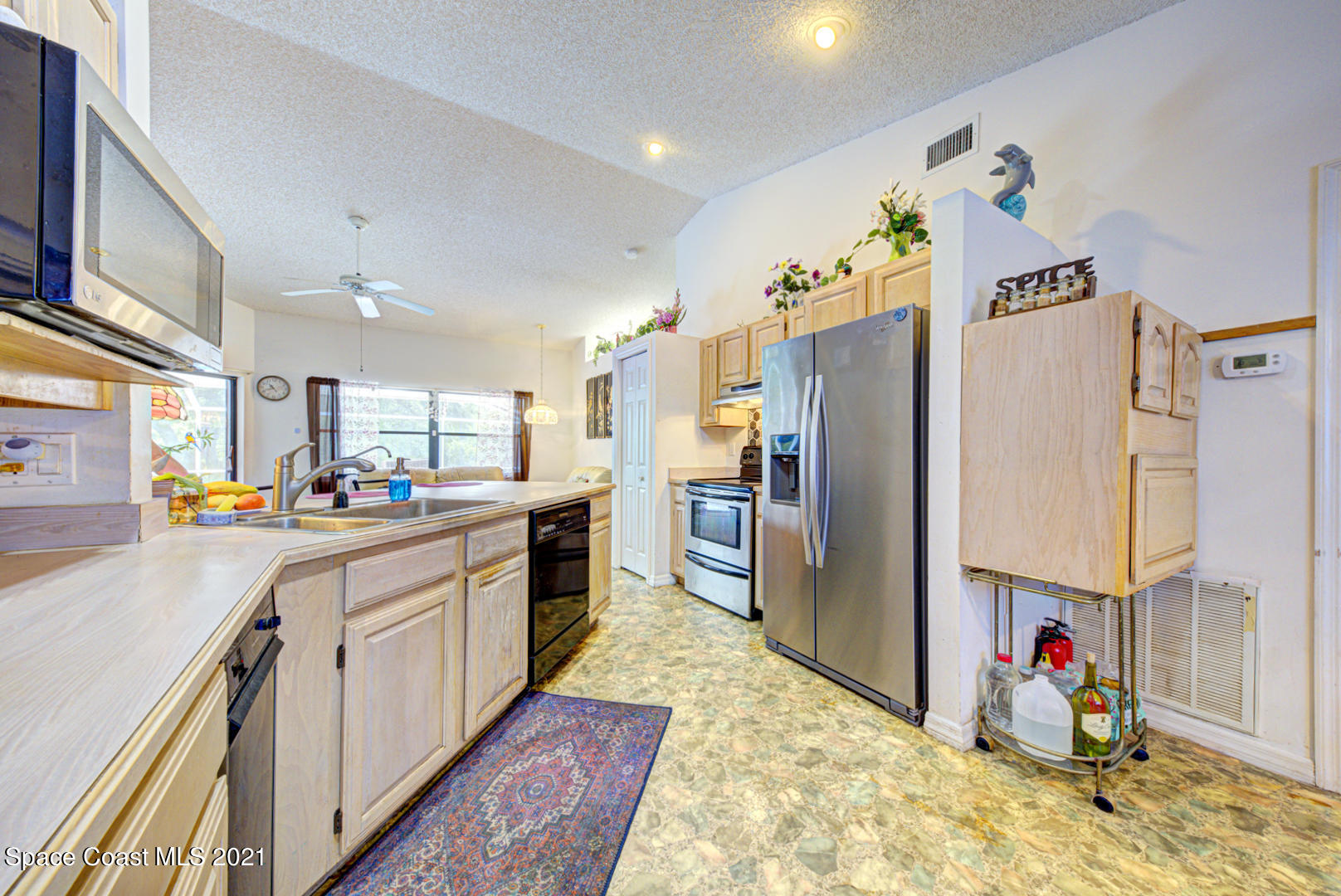 2225 Corey Road Malabar, FL 32950 - Photo 35 of 62 a kitchen with a refrigerator and a sink