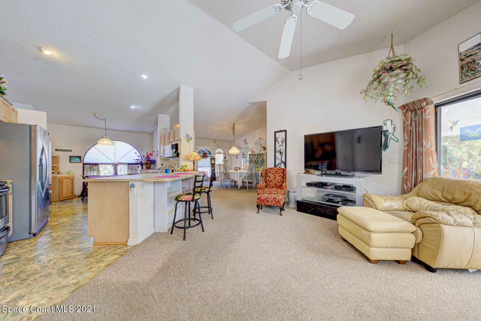 2225 Corey Road Malabar, FL 32950 - Photo 39 of 62 a living room with furniture flat screen tv and a chandelier