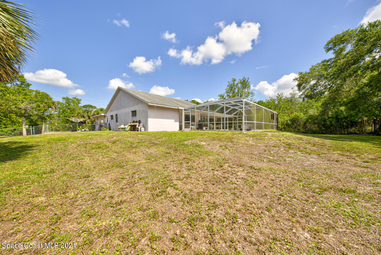 2225 Corey Road Malabar, FL 32950 - Photo 10 of 62 a house view with swimming pool and trees in the background